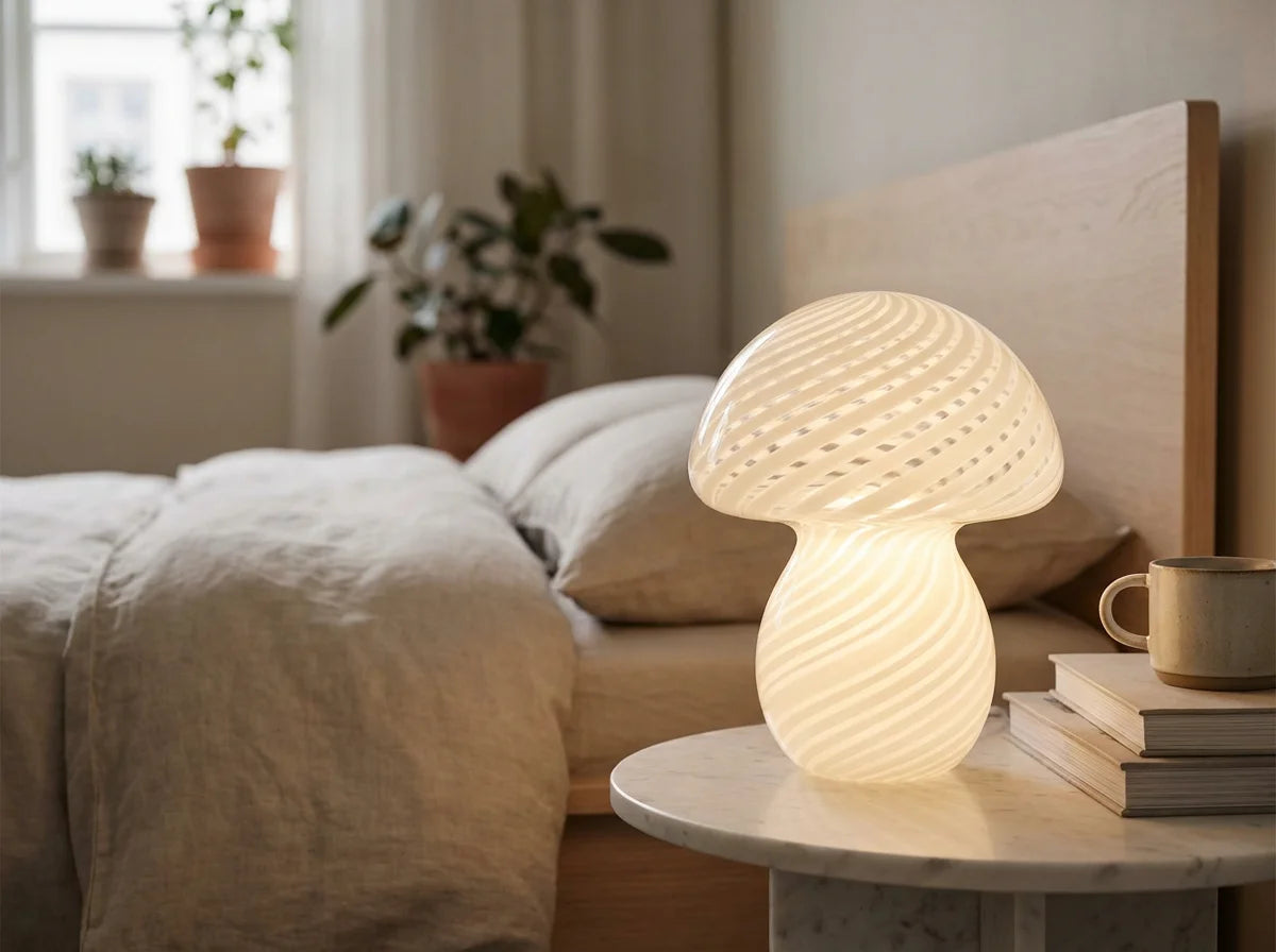 Glass mushroom lamp on marble nightstand in Scandinavian bedroom warm ambient light