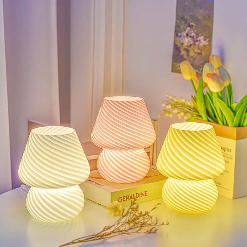 Glass mushroom table lamps white and pink swirl stripe glowing warm light bedroom scene